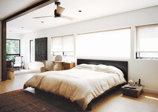 In the master bedroom, a custom bed by Jason Micciche is outfitted with linens from Marimekko; the ceiling fan is by Fanimation.