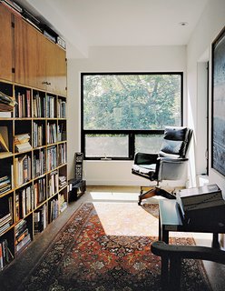 In Mathesius’s office on the third floor, an antique armchair, a rug, and a bookshelf made from salvaged wood create a cozy, sun-filled reading nook.