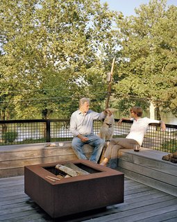 The staggering of the shipping containers created a series of decks in the rear of the home, which overlooks the Delaware River. A mix of vintage finds and pieces designed by Mathesius, including a Cor-Ten steel fire pit on the second-floor deck, furnish a majority of the home.