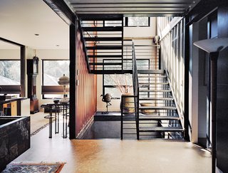 Moseley notes the home’s distinctive staircase as one of her favorite features. "When the steel was ordered from the steelyard," she says, "it was marked with our metalworker’s name, for easy pickup. That scribble still exists in random places in the staircase and is very industrial—we love it!" Hand-welded by Mike Carman, a local contractor, the staircase runs through all three floors, and it was custom-sized to fit the dimensions of the shipping containers, measuring nine-feet-six-inches tall and eight-feet wide.