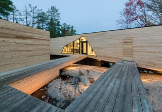 Prefab Made This Super Remote House in the Ontario Wilderness Possible - Photo 2 of 3 - The three-bedroom home is connected to a dock house, garage, and vegetable garden by a network of wood walkways and decks.