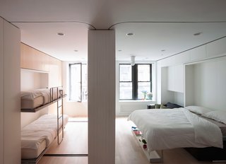 This concept apartment presented by LifeEdited in SoHo shows how much one can fit in 420 square feet. Murphy beds make it possible to sleep four. When they're not in use, a large dining table can be pulled out. Heavy red curtains pull out of the walls to enclose each room for maximum privacy and sound control.