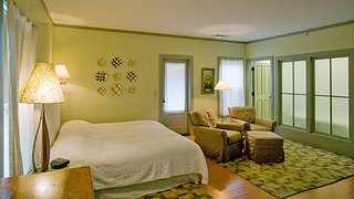 Porches Inn, North Adams, Massachusetts - Photo 6 of 21 - With four primary color schemes featured, headboard walls are painted terra cotta, pale blueberry, celery green, and sage green to complement wooden floors painted olive green, red, pumpkin and buttercup.<br><br>As part of her creative process Fitzpatrick conceptualized the design for each room by first establishing its color combination, and then matched vintage and modern pieces to accentuate the hues.