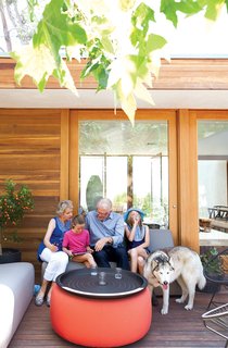 Daughters Ingrid and Jane catch up with their grandparents on the Room & Board–furnished front deck.