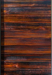 The charred-wood siding, inspired by shou sugi ban, comes in various stains, such as cherry (shown here). The blow-torching technique helps with resistance against insects, rot, water, mold, and fire.