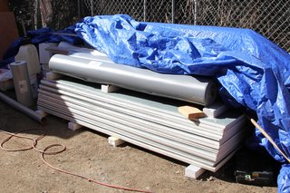 Dwell Home Venice: Part 14 - Photo 3 of 9 - Stacked roofing materials ready to be installed, including rolls of Versiflex PVC material and sheets of Securock roofboard for use with rooftop gardens. All roofing materials will be installed by JT Harris Inc.