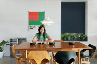 In Kathryn Tyler’s finished home, a palette of wood, concrete, and painted brick forms a neutral backdrop for vintage treasures, including a $30 dining table, $3 poster, and a set of 1950s Carl Jacobs Jason chairs she snagged on eBay for $400.