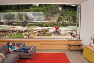 The family room is situated at the apex of the house, with picturesque views that extend <br><br>up the meticulously landscaped north slope. The concrete floor sits just low enough that the main elements of the scene—the succulent garden and large limestone ledges—are at eye level. A bank of NanaWall folding windows breaks up the fourth wall.