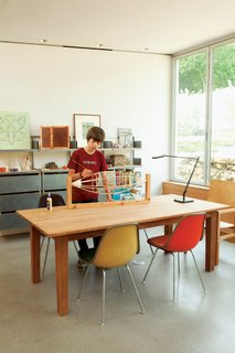 James works on his balsa-wood blimp in the family workspace, illuminated by a Kelvin LED Table Lamp from Flos.