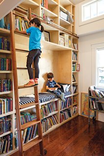 A former closet was transformed into a double-height library, complete with a reading nook and a rolling ladder from Spiral Stairs of America. "That’s my favorite part of the house," says Dan. "When I see Stella reaching for a book, there’s nothing better."