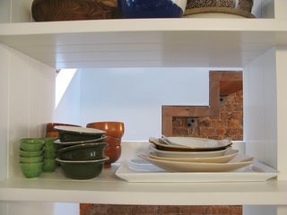City Modern Home Tours: Brooklyn - Photo 45 of 51 - Open shelves in the kitchen reveal a glimpse of the staircase.