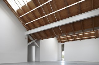 Reclaimed pine and plywood make up the interior ceiling which is pitched at an angle and fitted with pipes to allow drainage.