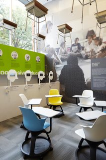 In the Center for Architecture’s double height gallery space, a grid of traditional school desks hang above a new, more flexible interpretation by Steelcase. There are also listening stations where visitors can hear the voices of 21st-century thinkers such as Katie Salen, James Paul Gee, and Howard Gardner, juxtaposed with key 20th century progressive educators whose contributions are listed behind.<br><br>Edgeless Schools takes into consideration how best to educate digital natives. "All these kids are growing up knowing they can access at a very young age the information of the world on a hand held device," Mellin says. "What does that mean in terms of formal education? One thing that is agreed upon is that while no one knows how this will be played out, there is a great emphasis on flexibility, and being able to use spaces in a variety of ways." Photo courtesy the Center for Architecture.