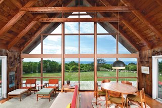 In the living and dining area, where mostly vintage Risom furnishings share space with a few new additions, the view facing north is framed by the wall of glass.