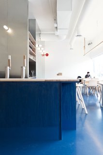 Color is deployed to grand effect in the space. The achieve the cerulean hue, the architects specified commercial acrylic paint and developed a hand-rubbing technique to control the opacity. "We're interested in common materials and creating space which is familiar and develops character and life with age," David says. "We look forward to the blue wash and soaped surfaces wearing in and the painted floor being reapplied and thickened."