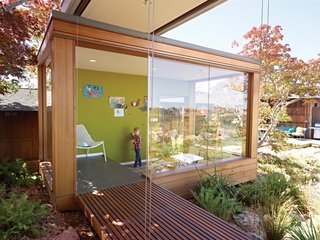 A Modern Prefab Addition to a Mid-Century California Classic - Photo 9 of 9 - Luc gets creative in the tearoom, which includes a small play area for the children. The walls of the space exemplify the simplicity of the new structures: Electrical and lighting components are run through the ceiling and floor, leaving many exterior walls unencumbered and free to hold floor-to-ceiling windows. On the raised platform is a Soleil lounge chair by Emu.