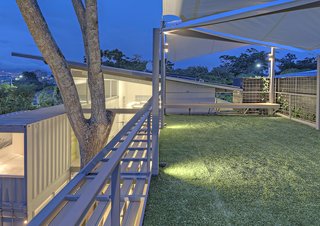 Trejos finished the roof with artificial grass, creating a terrace perfect for dinner parties as well as morning yoga sessions. The client's wife, a ballerina who teaches antigravity yoga, where participants are suspended from textiles, also made the suggestion to include the oversized cloth sails above the roof, a reference to her fitness routine.