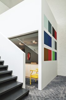 An installation by Willem Cole hangs in the gallery, which leads to an open stairway to the office and private bedrooms upstairs.
