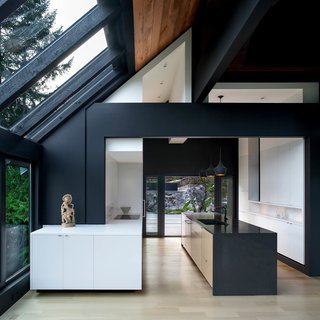 Originally built in the 1970s, this cliffside house in North Vancouver was in need of an improvement and update. The owners, both visually-minded artistic directors at gaming companies, embarked on a multi-stage renovation that added a sharp modern aesthetic with clean surfaces and volumes. The kitchen was originally a half-level down, creating a dip in between the dining room and adjacent patio. With the kitchen and outdoor area raised to the same level, movement is now smooth and continuous. 