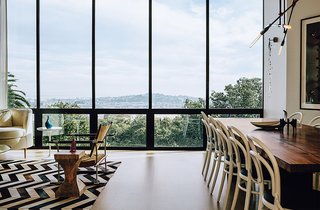 The living-dining room overlooks the neighborhood and the Bay beyond. The Safari chair was designed by Jens Quistgaard. Michael Thonet chairs are paired with a walnut table by Anthony Marschak for Original Timber Co.