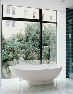 The bathroom features a tub by Benedini Associati for Agape, Dornbracht tub filler, and retractable shades.