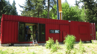 8 Companies That Are Revolutionizing Kit Homes - Photo 9 of 9 - Repurposed shipping containers serve as the primary materials for the houses and working spaces designed by ShelterKraft. The company's designs focus primarily on disaster relief projects, drawing from existing steel frames and skins in order to reduce the use of new materials. Their buildings range from small cargo cottages of 160-square-feet to 700-square-foot warehouses for industrial facilities. Alhough they come with electric power, heat and plumbing, they generally require a pre-existing concrete foundation and a local contractor to ensure a smooth, safe installation.