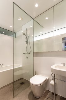 Situated behind the kitchen, the lower level bathroom is equally suited to cleaning up before a meal or taking a leisurely bath. Crisp white fixtures, including a Kaldewei Centro Duo bath, ensure that the bathroom feels as light and airy as the rest of the house.