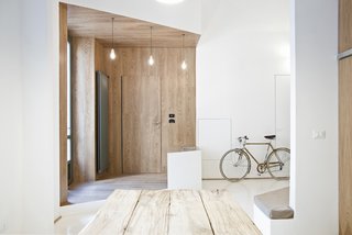 Filled with crisp lines and textural contrasts, the interior plan widens the small apartment by setting it apart, creating alcoves, living spaces, and sculptural dimension within the open white space.
