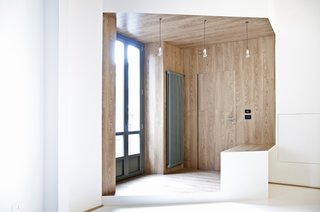 Framed by planes of wood, as well as a large pair of windows, the entryway exudes warmth.