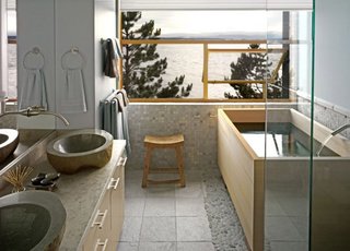 Japanese Soaking Tubs - Photo 7 of 13 - Grace Boyd’s favorite room has a stunning view of Puget Sound reflected in the Hinoki tub she had custom-sized by Roberts Hot Tubs. The clean lines of soaking tubs "work well in conventional bathrooms," says Roberts’ Andrew Harris, "no need to make the whole room Japanese-style." Grace echoed the grey of the sea and sky in the sinks and the silvery pebbles around the tub. After 32 years in West Seattle, she asked architect Mark Travers to build her a new house in the same spot- she couldn’t bear to lose her view. Tubs are popping up in real estate listings as a selling point; new owners can have an existing tub sanded to reveal a fresh layer of pristine scented wood. Photo courtesy of: Roberts Hot Tubs