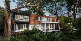 This Modern Miami House Feels Like It's in the Middle of the Jungle - Photo 1 of 12 - The house is located in the Camp Biscayne area of Coconut Grove, a neighborhood in Miami. Its main volume is clad in Prodema.