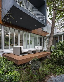 This Modern Miami House Feels Like It's in the Middle of the Jungle - Photo 3 of 12 - The cantilevered upper volume shades a deck on the ground floor.