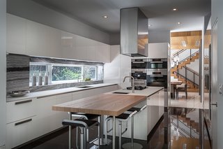 This Modern Miami House Feels Like It's in the Middle of the Jungle - Photo 8 of 12 - A view of the kitchen.