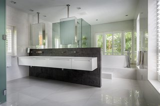 This Modern Miami House Feels Like It's in the Middle of the Jungle - Photo 9 of 12 - Echoing the facade, dark stone and wood are used throughout the interiors.