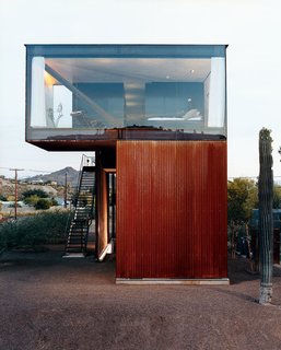 In this glass-enclosed master bedroom, a LC4 armchair faces the master bed. The moveable frame adjusts along the base, allowing the sitter to switch from upright to full recline, or lounge at a number of other sitting angles.