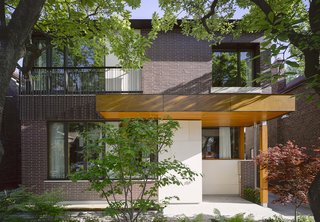 Smart Tech Makes this Modern Home Ultra Energy Efficient - Photo 1 of 11 - Located in Toronto, the Bedford Park House embodies an architectual hat trick: it's smart from a technological standpoint, it's energy efficient, and it's designed so the residents, a doctor and his wife, can age in place. Architect Alex Tedesco, a senior partner at LGA Architectural Partners, created a thoughtful design grounded in the advanced building science and that embodies the principles of modernism. The facade is clad in Rum Raison Velour brick by Belden with Douglas fir accents.