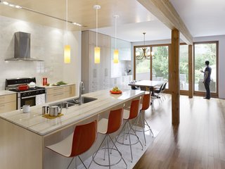 Smart Tech Makes this Modern Home Ultra Energy Efficient - Photo 4 of 11 - The kitchen is outfitted with a duel-fuel range by Bosch, a Diamonte Canopy hood by Faber, a LaPerla dishwasher by Miele, French-door refrigerator by LG, Blanco sink, and Compact Smart overn by Breville. Catifa 46 stools by Arper are stationed at the bar. The counters are quartz and the cabinets are solid maple. "Given that the owners’ intention was to stay and age in the house, we decided that the materials needed to be elegant and timeless and, in essence, could also age well in place," Tedesco says. "This led to devising a refined and warm palette of natural finishes. White carrara marble, oiled clear Douglas fir, and maple floors and millwork create a light, warm interior with a reddish hue that emanates when the sunlight washes the woods. The selection process included R-and-D on the materials to assess their ability to be both robust enough to handle every day wear and tear in the short term and acquire a beautiful patina long term. We also researched MSDS charts to ensure they were safe, non-toxic, and would not off-gas."