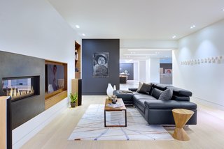 From a Flower Bulb Factory to an Entertainment Hub - Photo 3 of 9 - "Inside," says designer Daniel Harland, "we wanted to keep the material palette fairly minimal, especially since many spaces look onto each other." Most of the millwork is a combination of quarter-cut American black walnut and acid-finished cold-rolled steel. The artwork is by Dana Prieto, the coffee table and side table are by Hollis+Morris, and the area rug is by Kelly Wearstler.