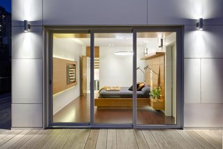 From a Flower Bulb Factory to an Entertainment Hub - Photo 5 of 9 - The emphasis on linearity and natural materials continues into the master bedroom, where the flooring is a brown leather plank floor from Torlys. The bedside lights are from Dark Tools.