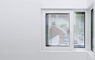 From a Flower Bulb Factory to an Entertainment Hub - Photo 8 of 9 - Inside, perforated window screens reference the light fixture in the courtyard, "offering an abstract, fragmented glimpse of the tulips inside," explains Harland.