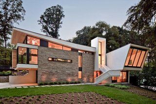 Svenson calls the floating aluminum stairway "a major sculptural element." He adds, "We really wanted to celebrate the entry," which is elevated because the site is ten feet higher in the rear. The earthy stucco and local stone cladding keep the home rooted to its landscape.