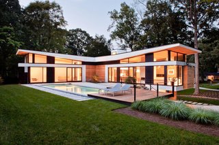 The home’s T-shaped layout forms a courtyard accessible by its two "social wings," fitted with massive Kawneer sliding doors made for auto showrooms.