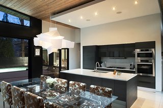Candy Sarvis loves feeling connected with dinner guests while she cooks. The African teak kitchen cabinetry is by Pedini, with Miele appliances. A Big Bang pendant by Foscarini illuminates the Montecarlo table by Cattelan Italia.