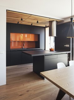 Joaquin Altamirano and Silvia Martín worked with Daniel Bergman Vázquez of Estudio Untercio to create an open-plan oasis in an apartment building in central Madrid. Estudio Untercio designed the medium-density fiberboard cupboards, which are coated with lacquer paint matching the ceramic-porcelain countertops. The tubular hood above the island is by Teka.