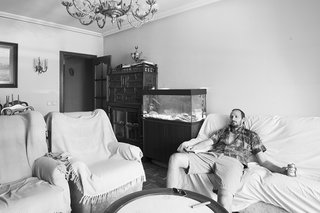 Vázquez poses in the pre-renovated living room.