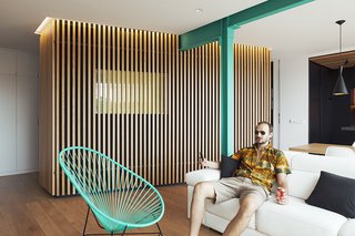 Here, Vázquez poses on a sofa by Avant Haus in the new space. The slatted enclosure houses a bathroom; a one-way mirror lets users see out without forfeiting their privacy.