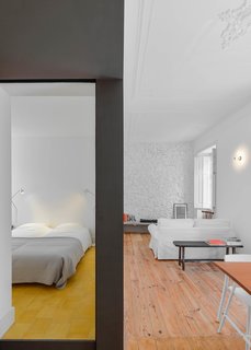 José Andrade Rocha brought a 592-square-foot apartment in Lisbon back to life by restoring its original, early 20th-century materials, strengthening its relationship with the street, and defining its public and private spaces. A series of gray sliding doors divide the living spaces.
