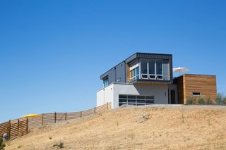 Two adapted prefabricated modules perch above a site-built garage. Exterior materials include sustainably harvested cedar rainscreen; HardiePanel made from recycled materials; and standing seam metal siding, known for its longevity and energy efficiency.
