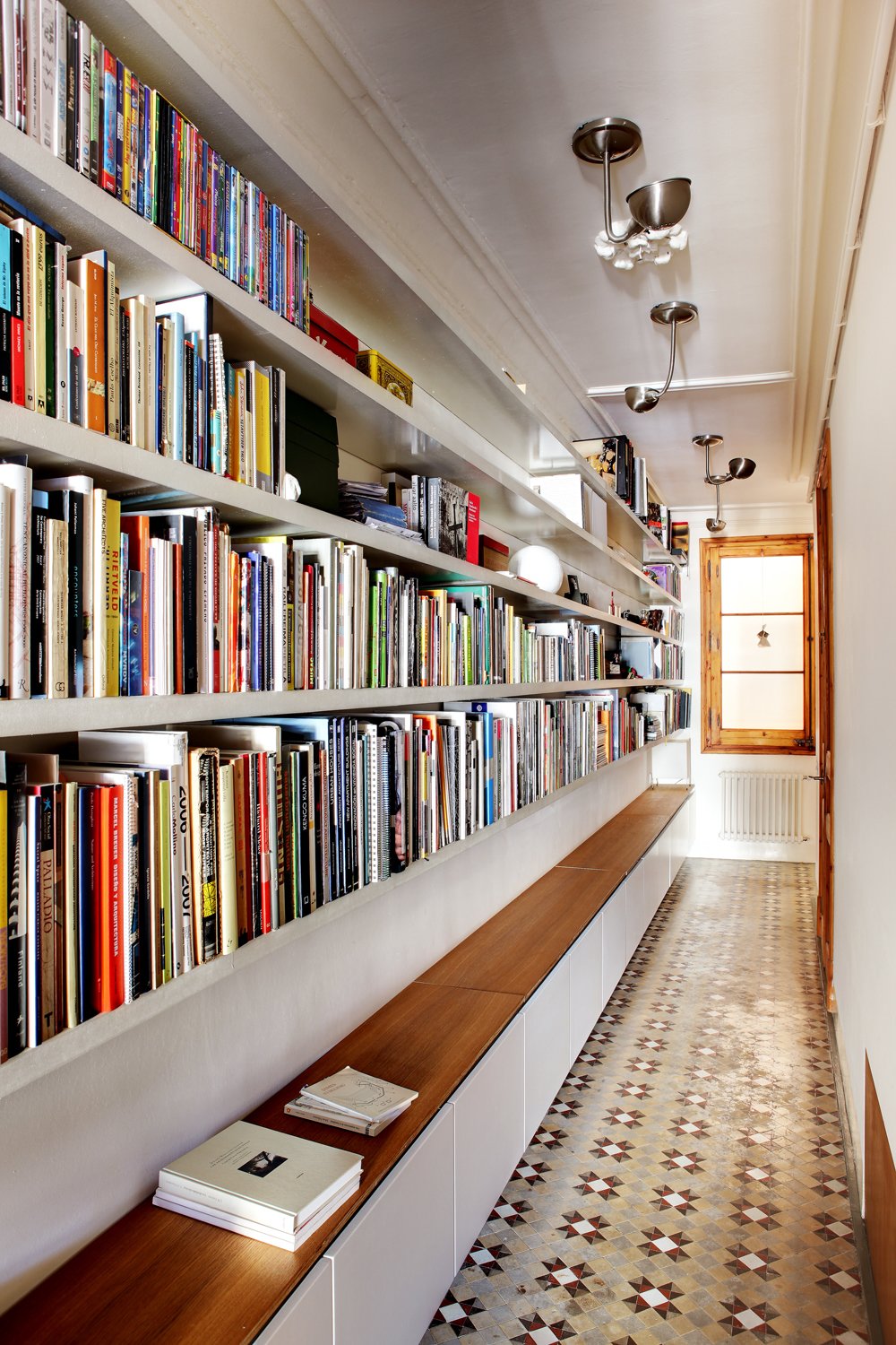 You may think that a library has to be its own room, but books can be stored and read just about anywhere. Lining a hallway with books turns it into a library that you’ll walk through, and be inspired by, every day. Cabinets below provide extra storage and even a place to sit and read.