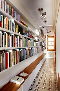 You may think that a library has to be its own room, but books can be stored and read just about anywhere. Lining a hallway with books turns it into a library that you’ll walk through, and be inspired by, every day. Cabinets below provide extra storage and even a place to sit and read. 